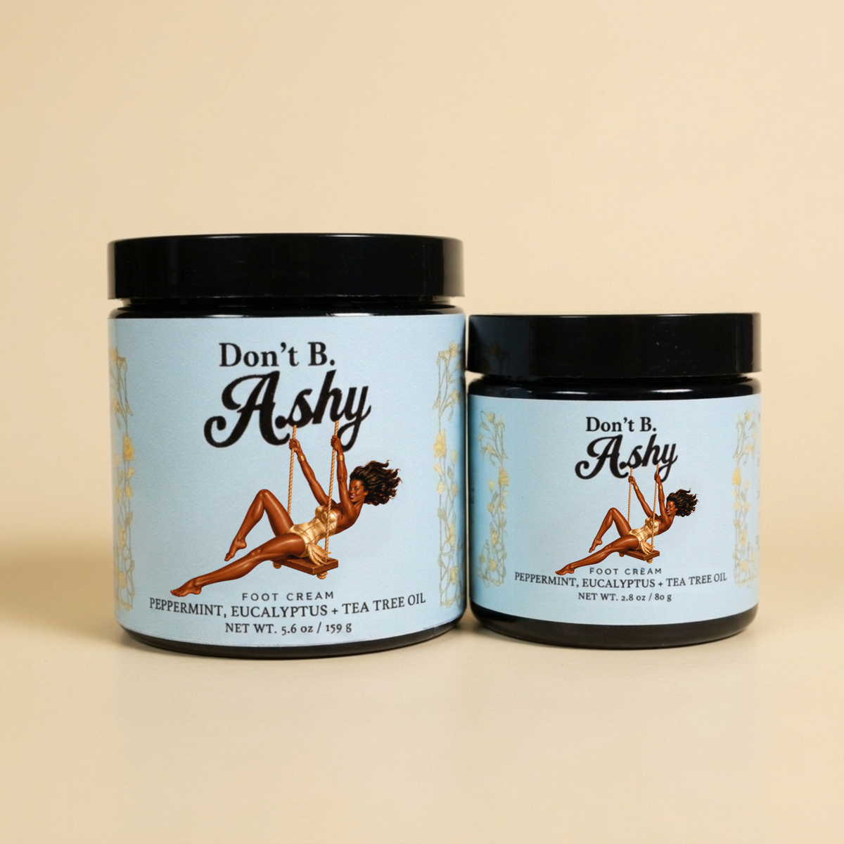 Don’t B. Ashy Peppermint, Eucalyptus + Tea Tree foot cream in 5.6 oz and 2.8 oz black glass jars with ice-blue labels